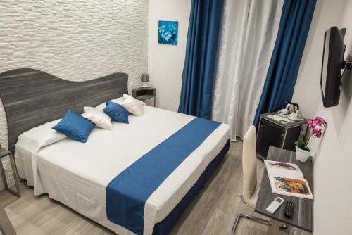 a bedroom with a bed with blue and white pillows at B&B Elegance in Taormina
