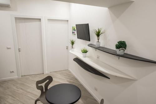 a room with a chair and a tv on a wall at B&B Elegance in Taormina