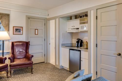 a living room with a chair and a kitchen at First Colony Inn in Nags Head