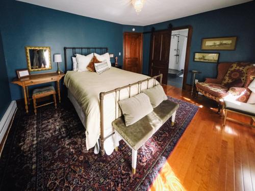 a bedroom with a bed and a couch and a chair at Burdett House Bed & Breakfast in Burdett