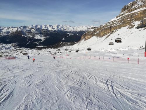 un grupo de personas esquiando por una pista de esquí cubierta de nieve en Appartamento Campiglio, en Madonna di Campiglio