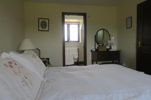 a white bed in a bedroom with a mirror at Highfield in Hay-on-Wye