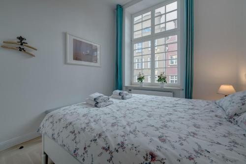 a bedroom with a bed and a window at Apartamenty Mariacka in Gdańsk