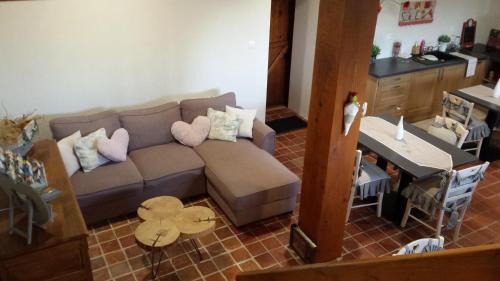 ein Wohnzimmer mit einem Sofa und einem Tisch in der Unterkunft La Bastide du Moulin - Mont St Michel in Moidrey