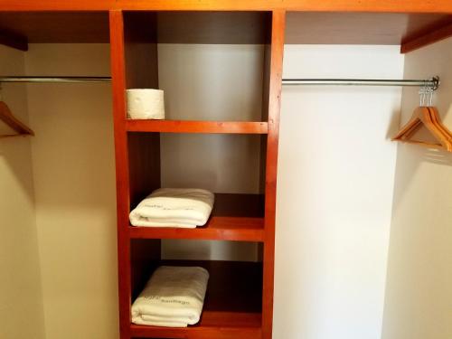 a closet with wooden shelves and white towels at Hotel Santiago in Jalpan de Serra