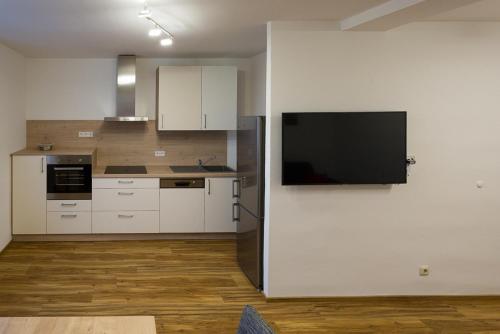 eine Küche mit weißen Schränken und einem Flachbild-TV in der Unterkunft eder-home in Reisenberg
