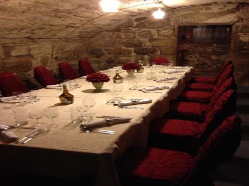 a long table with wine glasses and red chairs at Clennell Hall Country House - Near Rothbury - Northumberland in Alwinton