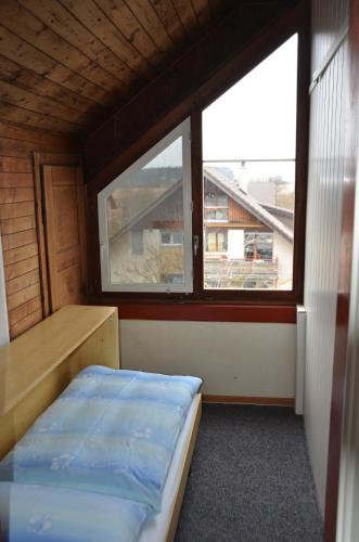 a small room with a bed and a window at Hotel Restaurant Bahnhof in Schüpfen