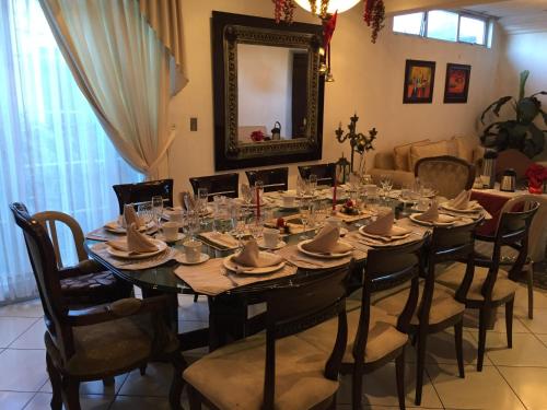 a dining room with a table with chairs and a mirror at Apartamentos Comodos Cerca del Aeropuerto in Guatemala