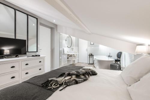 a bedroom with a bed with a television and a bathroom at Résidences Alticimes in Brides-les-Bains
