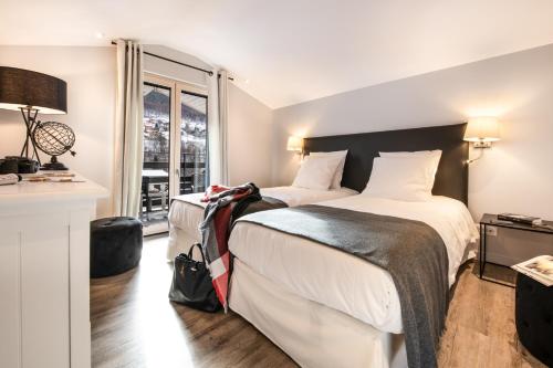 a hotel room with two beds and a window at Résidences Alticimes in Brides-les-Bains