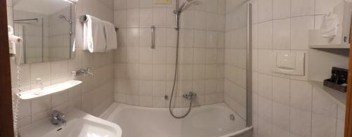 a bathroom with a shower and a tub and a sink at Braustüble und Hotel zur Post in Weiler-Simmerberg
