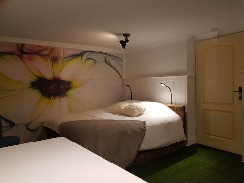 a bedroom with a flower mural on the wall at B&B Usselo Klein, fijn en uniek! in Enschede