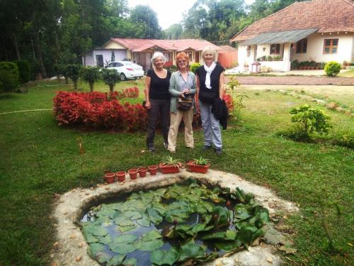 a group of three women standing in a garden at Edgestay in Mudigere