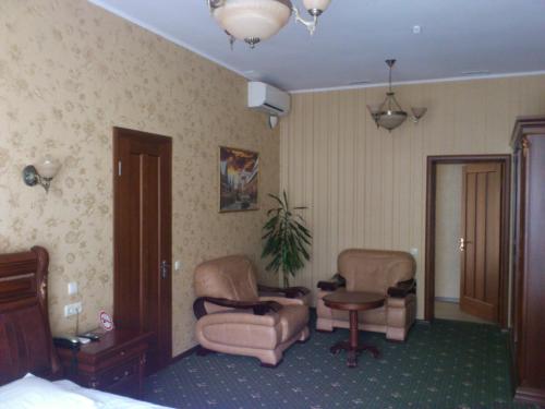 a hotel room with two chairs and a table at Status Hotel in Poltava