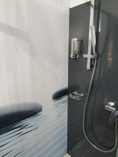 uma casa de banho com um chuveiro, um lavatório e um espelho. em Art-Hotel Erlangen em Erlangen