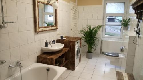 ein Badezimmer mit einem Waschbecken, einer Badewanne und einem WC in der Unterkunft Villa Heimburg in Thale