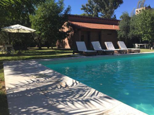 una piscina con tumbonas y sombrilla en Suter Petit Hotel en San Rafael