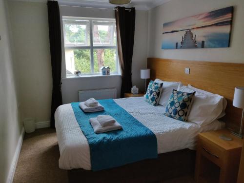 a bedroom with a bed with two towels on it at Hartford Court, East Cliff, Bournemouth. Walk to beach and town in Bournemouth