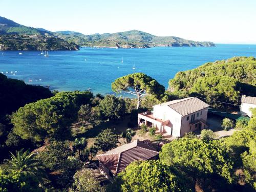 an aerial view of a house on a hill next to the water at Capo Perla Apartments in Capoliveri