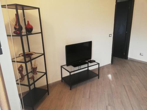 a living room with a television on a shelf at B&B Al Calcandola in Sarzana