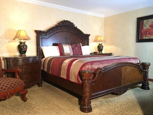 a bedroom with a large wooden bed with two lamps at Acorn Motor Inn in Oak Harbor