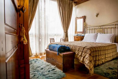 a bedroom with a bed and a large window at Hagiati Guesthouse in Edessa