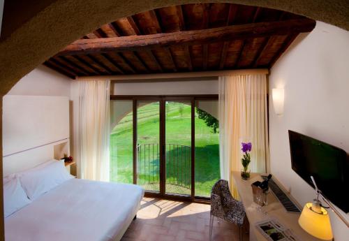 a bedroom with a bed and a large window at Locanda Sant'Agata in San Giuliano Terme