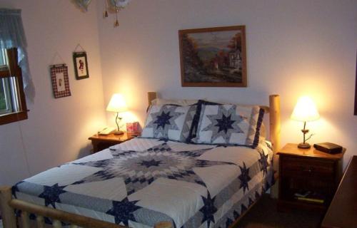 1 dormitorio con 1 cama con edredón azul y blanco en A Little Slice of Smokey Mountain Heaven with Wifi, en Franklin