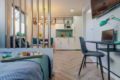 een slaapkamer met een bed, een bureau en een computer bij Ideal Apartments Green & Blue in Gdańsk