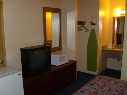 Zimmer mit einem TV auf einer Kommode und einer Mikrowelle in der Unterkunft Stagecoach Inn Motel in Molalla