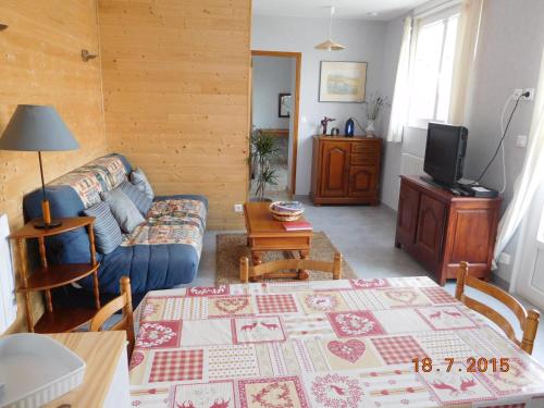 een woonkamer met een bank en een tafel bij gîte "au pied de Cristayes " in Gap