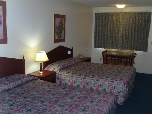 ein Hotelzimmer mit 2 Betten und einem Fenster in der Unterkunft Stagecoach Inn Motel in Molalla