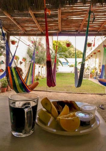a plate of fruit and a drink and hammocks at Grand Hostal Playa in Playa del Carmen