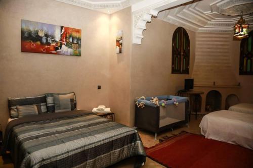 ein Schlafzimmer mit einem Bett und einem TV in einem Zimmer in der Unterkunft Atlas Resorts in Aït Ourir