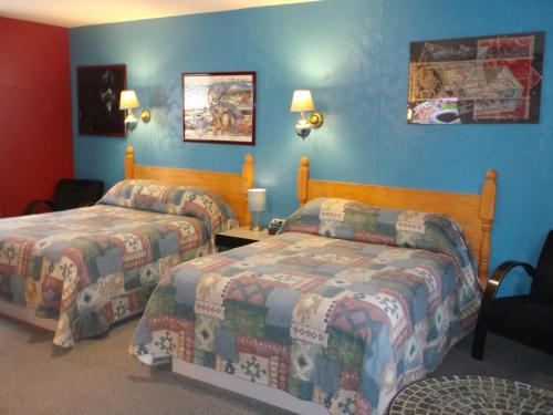 Habitación de hotel con 2 camas y paredes azules en Haileybury Beach Motel, en Haileybury