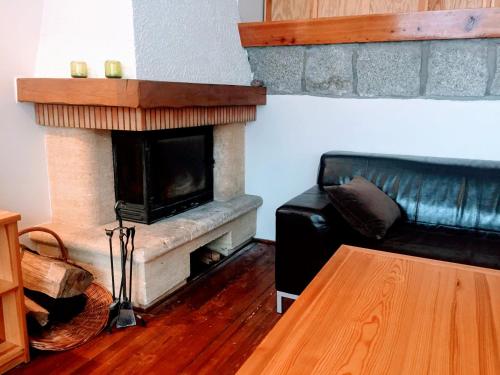 a living room with a fireplace and a leather couch at Tumitak Sarnia Family & Friends in Karpacz