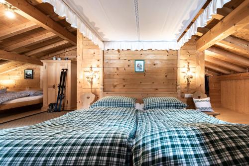 a large bed in a room with wooden walls at Gämsle Hotel, Wirtshaus & mehr in Schoppernau