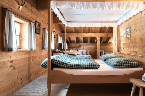 a bedroom with a bed in a wooden house at Gämsle Hotel, Wirtshaus & mehr in Schoppernau