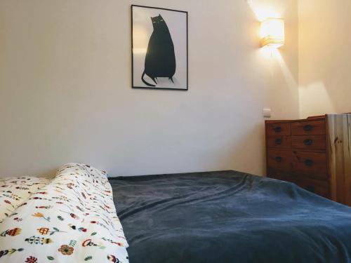a bedroom with a bed and a picture of a cat on the wall at Tumitak Sarnia Family & Friends in Karpacz