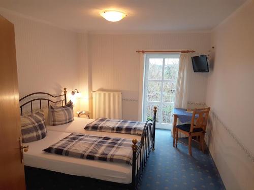 a hotel room with two beds and a window at Landhotel Nonnenroth in Hungen