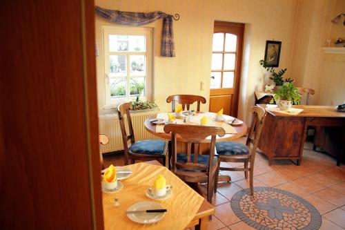 ein Esszimmer mit einem Tisch, Stühlen und einem Fenster in der Unterkunft Landhotel Nonnenroth in Hungen