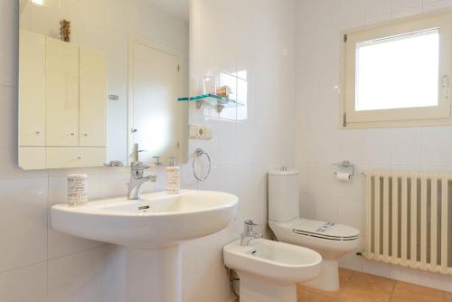 a white bathroom with a sink and a toilet at Apartamento "El Lilà" - Parking incluido in Olot