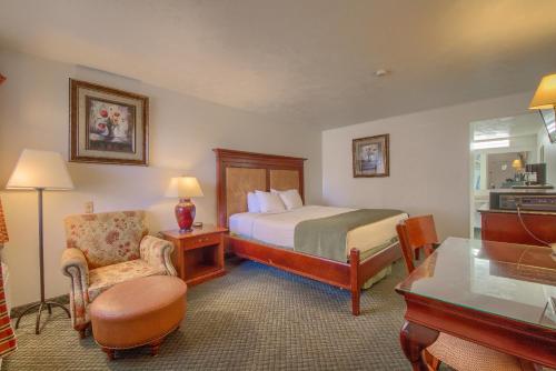 a hotel room with a bed and a chair at Americas Best Value Inn Uvalde in Uvalde