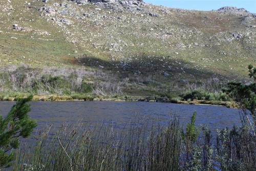 a body of water in front of a mountain at South Peninsula Beach Apartment in Cape Town