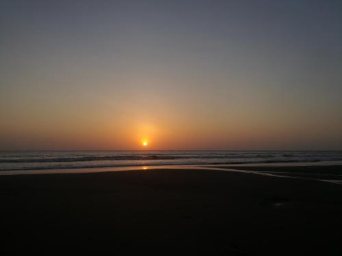 a sunset on the beach with the ocean at Posada Villamaga in El Valle
