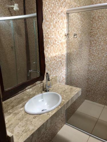 a bathroom with a sink and a glass shower at Pantanal Ranch Meia Lua in Esperança
