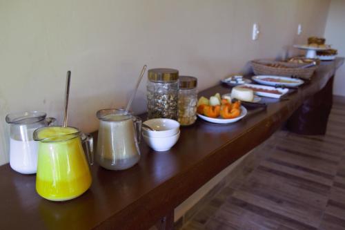 un lungo tavolo con molti barattoli e piatti di cibo di Pantanal Ranch Meia Lua a Miranda