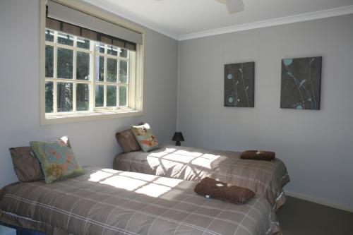 a bedroom with two beds and a window at The Old Coolstore - Braeburn Apt in Merricks North