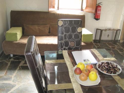 a living room with a table with a bowl of fruit at Casa do Retiro in Pedrógão Grande